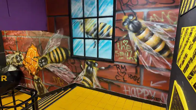 Mural de abejas, el símbolo de Manchester, en las escaleras de Afflecks