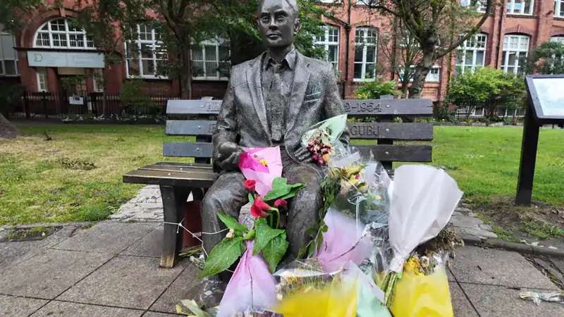 La estatua de Alan Turing con flores en Sackville Gardens, Manchester