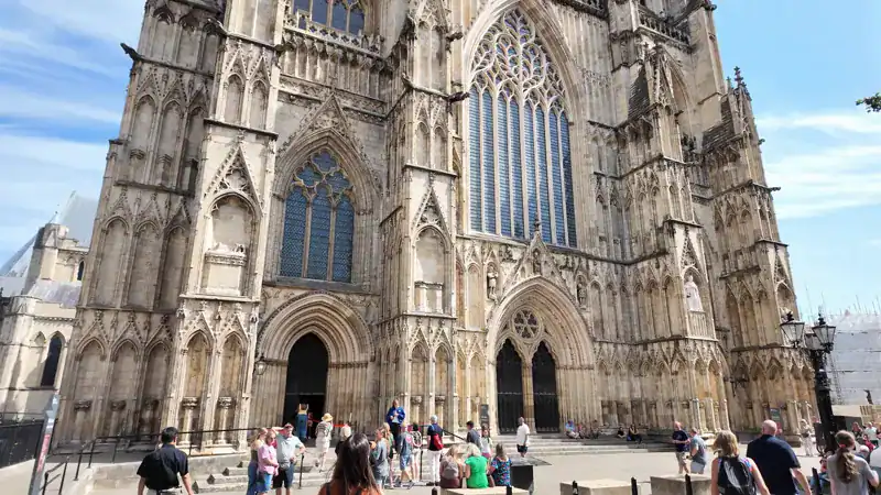 Fachada oeste de la Catedral de York (York Minster) con sus dos torres y visitantes en la entrada