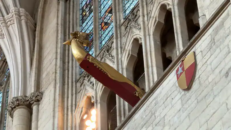 Cabeza de dragón roja y dorada en la pared de la nave de la Catedral de York