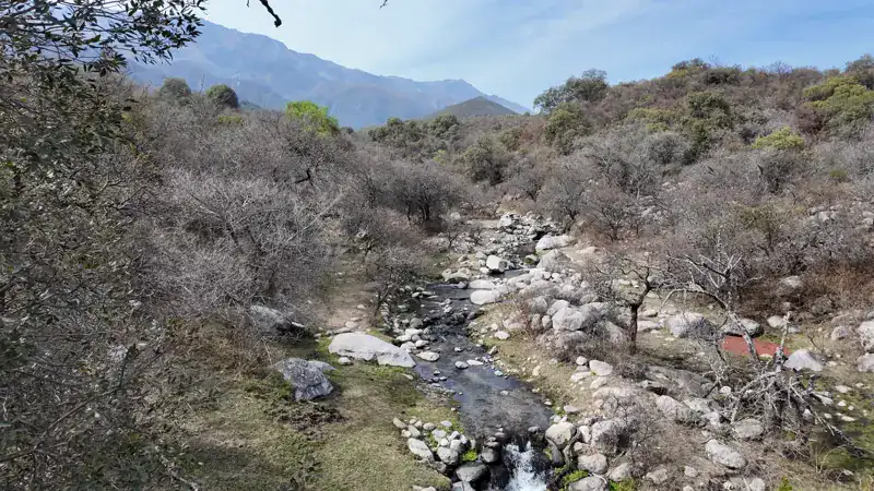 Arroyo entre piedras en Los Molles, con las sierras del Champaquí al fondo