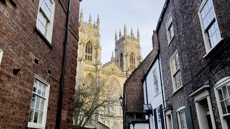 Precentor's Court, callecita de casas de ladrillo con las torres de la Catedral de York al fondo