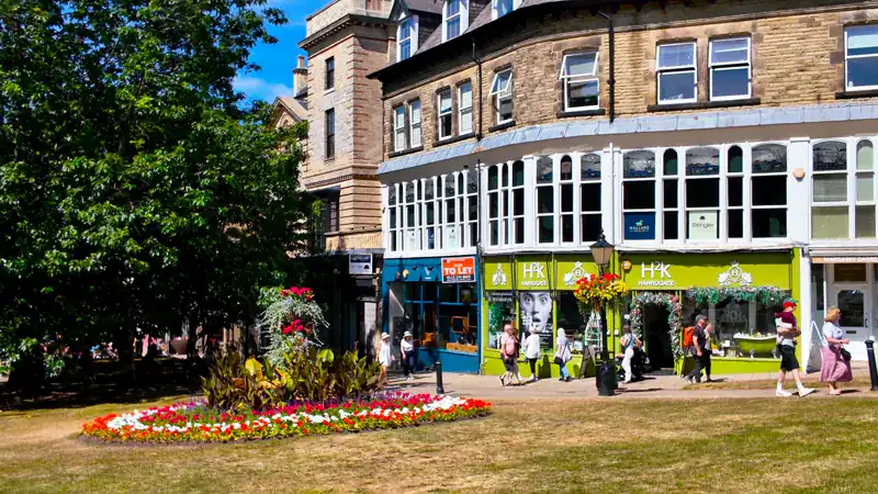 Esquina con tiendas y un cantero de flores en el centro de Harrogate